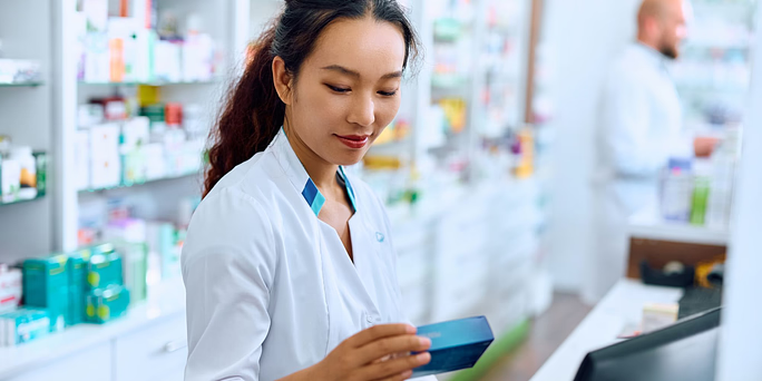 pharmacist looking at a box of pills